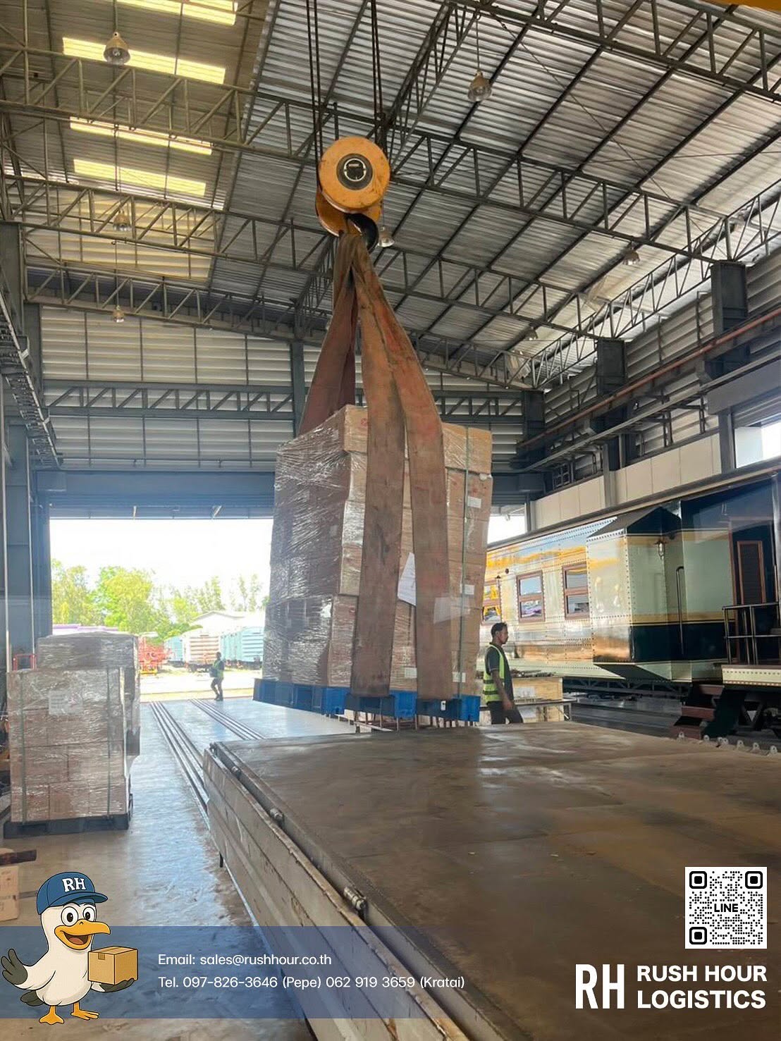 Palletized cargo being lifted by an overhead crane inside a facility